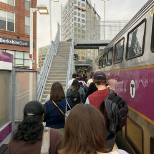 A line of commuters exits the train and walking away.