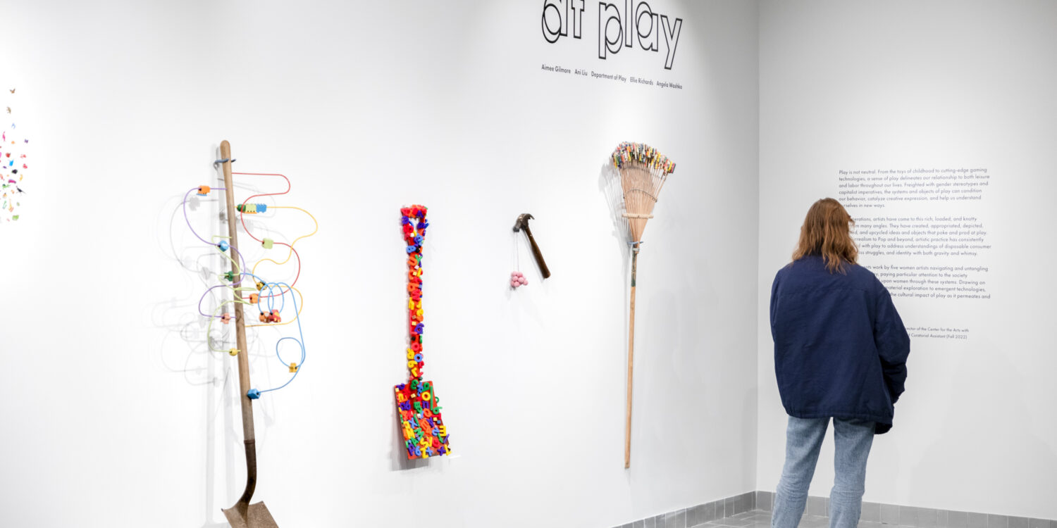 Image shows a gallery attendee reading the wall text at Gallery360's 2023 exhibition "At Play."
