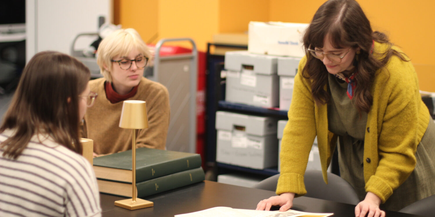 Image shows Outreach and Reference Archivist, Molly Brown, perusing a book in the Northeastern University Library's newly renovated space.