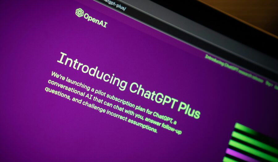 Image shows a computer on the ChatGPT website. The page says "Introducing ChatGPT Plus."