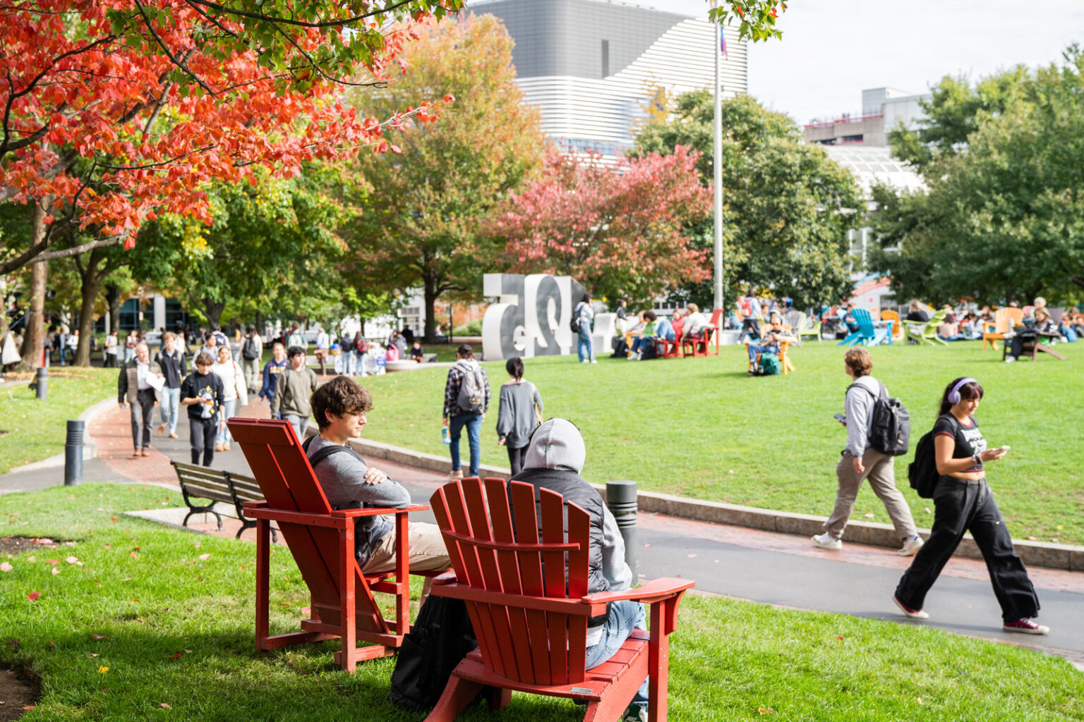 students sitting and walking outdoors in autumn