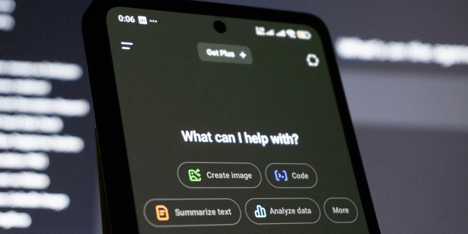 Photo that shows a phone screen with a genAI software screen saying "What can I help with?" There are several option buttons, including "Generate Image," "Code," "Summarize text," "Analyze data," and "more."