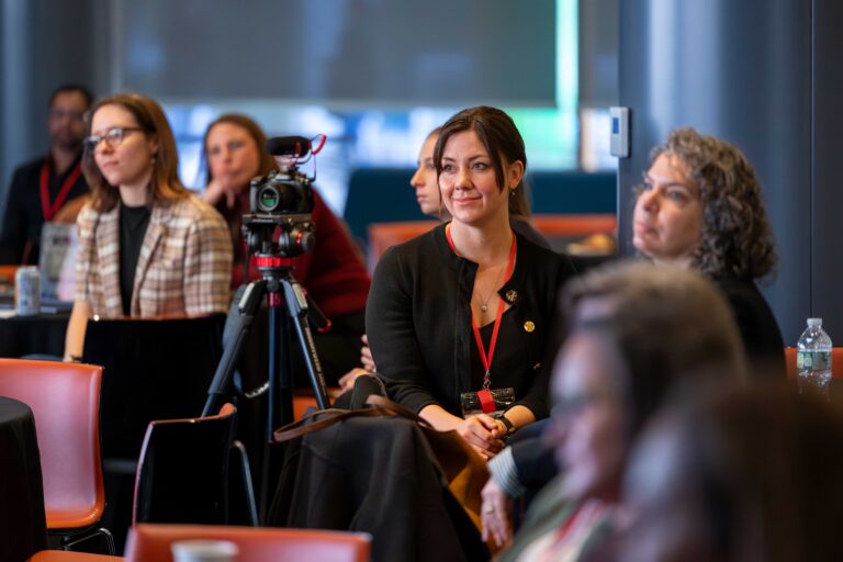 Image of Ragan Glover sitting in a lecture style room.