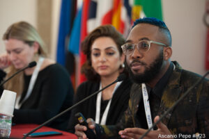 Close-up angle of Okereke speaking on a solutions journalism panel at the 2023 International Journalism Festival.